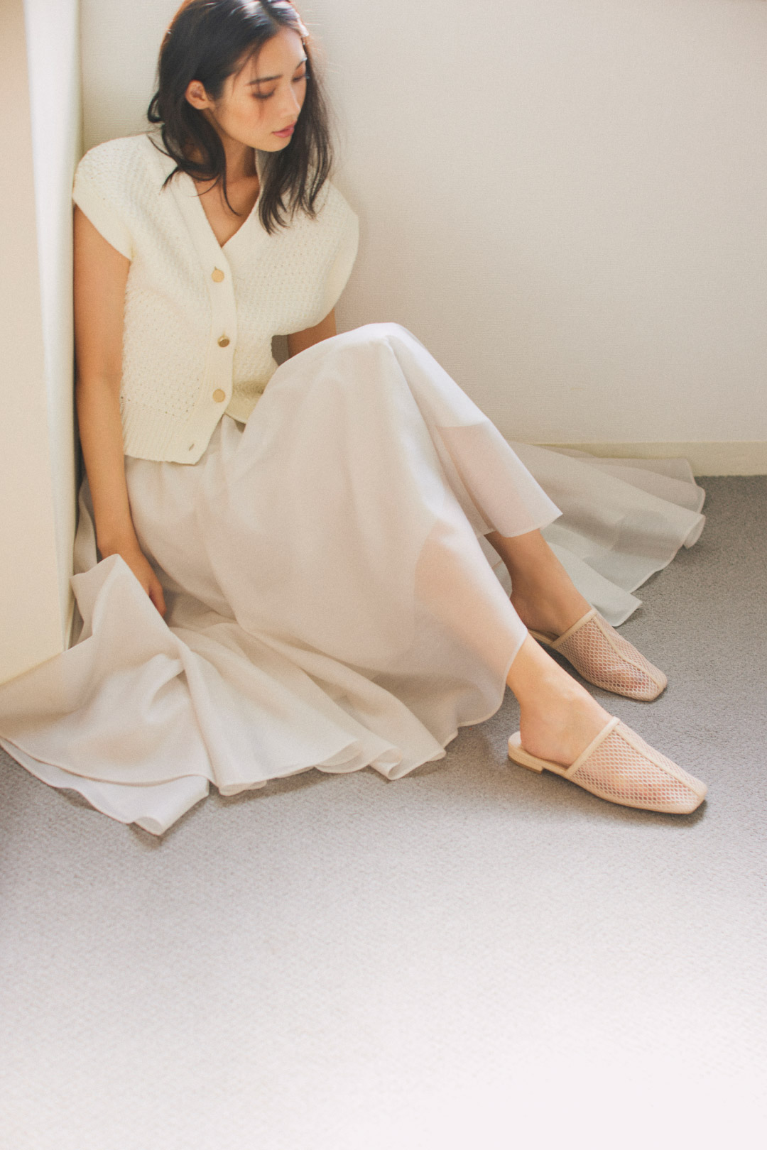 アイボリーのジレ・アイボリーのパンツを履いた女性