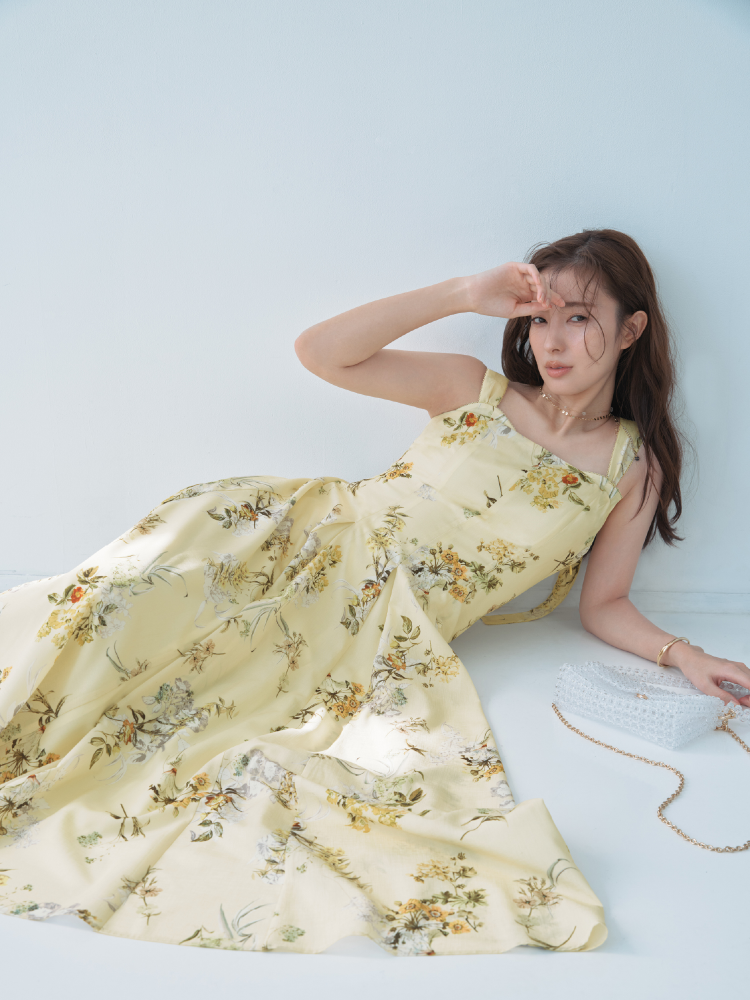 レイヤードライクフラワーワンピース・MIXパーツネックレス・クロスラインバングル・フルーツモチーフビーズバッグを着用した女性