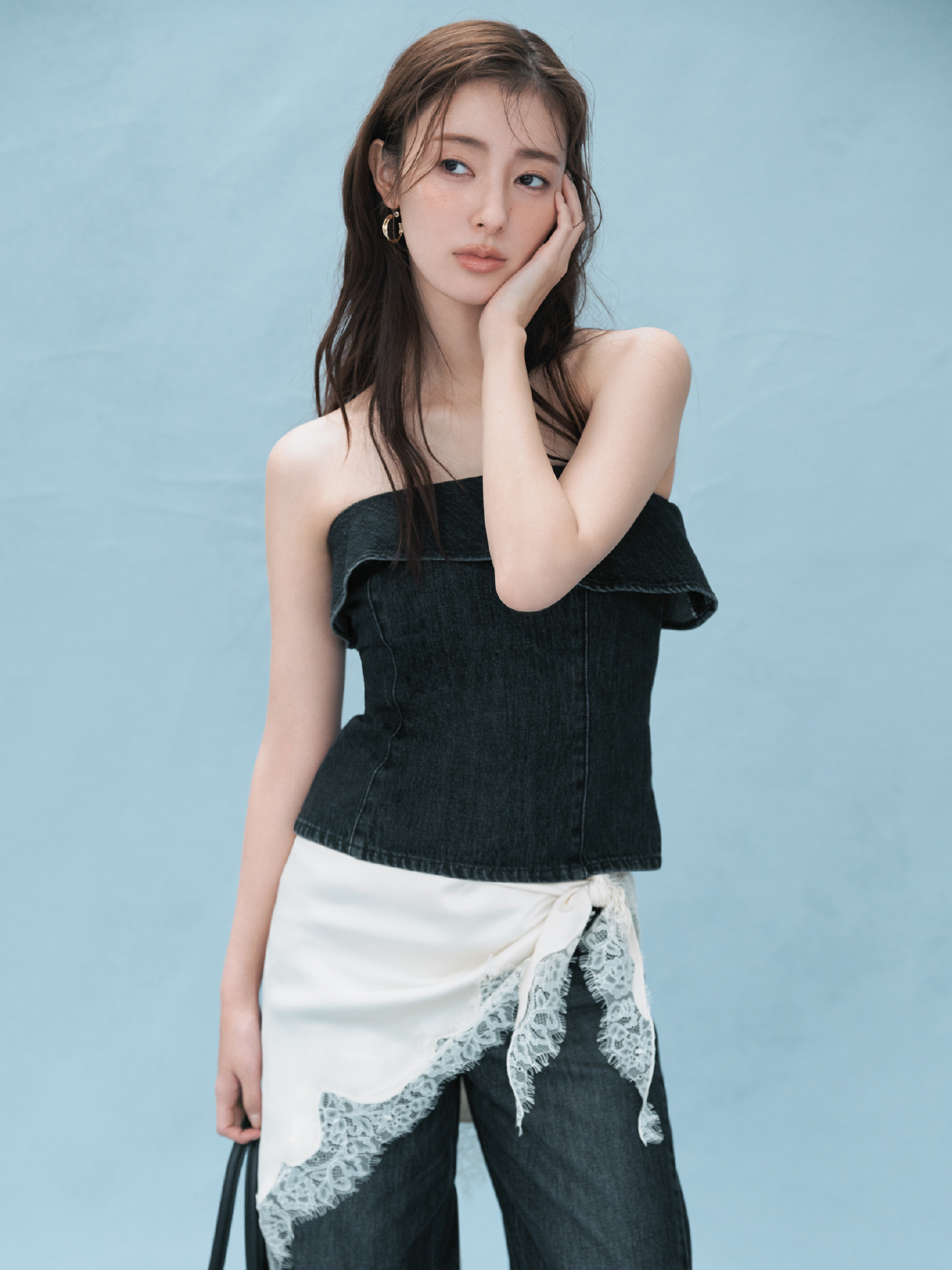 2wayデニムビスチェ・バレルフォルムデニムパンツ・クロスラインフープピアス・レーストリムスカーフ・ベルトデザインレザートートバッグを着用した女性