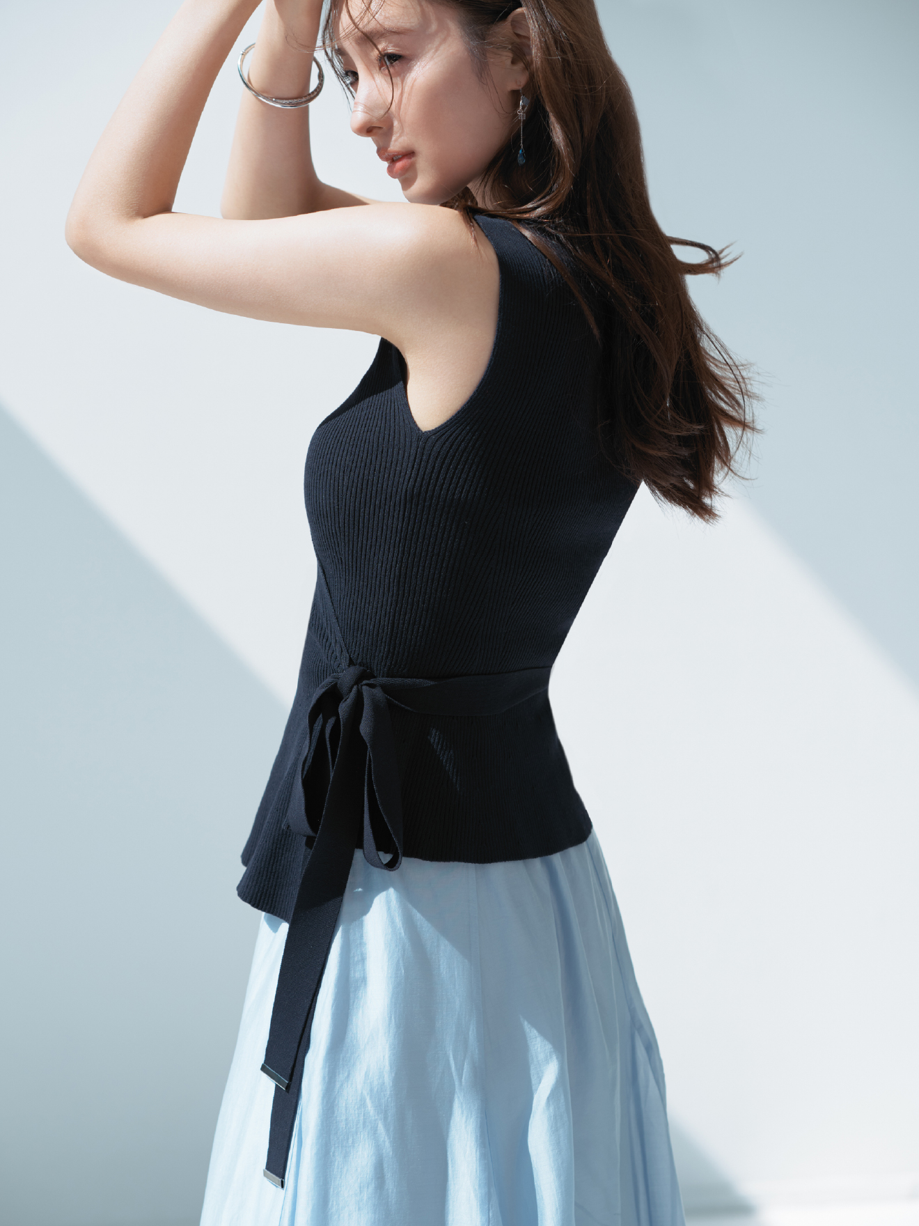 2wayニットセットアップワンピース・MIXパーツピアス・クロスラインバングルを着用した女性