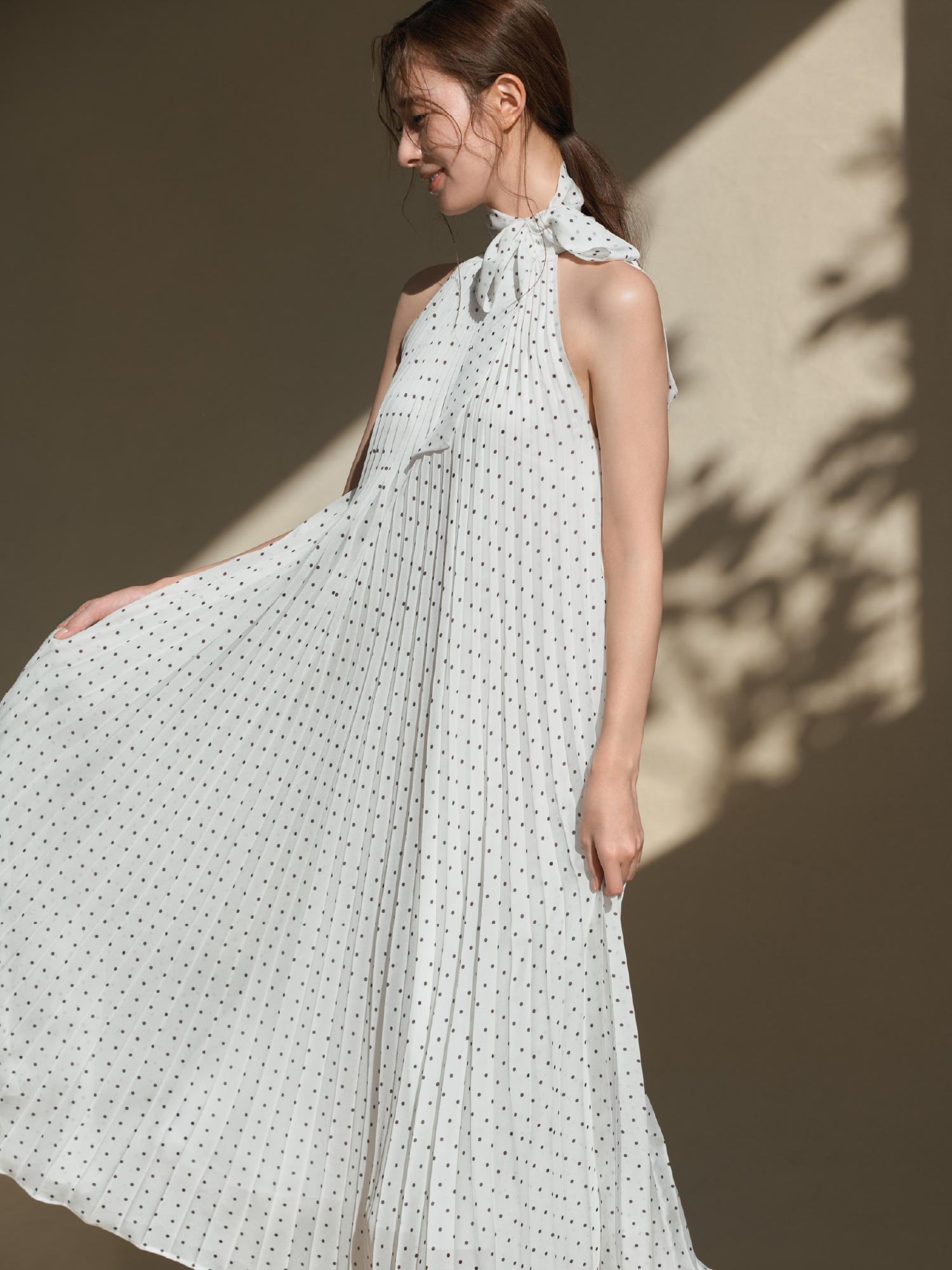 2wayプリーツホルターネックワンピースを着用した女性