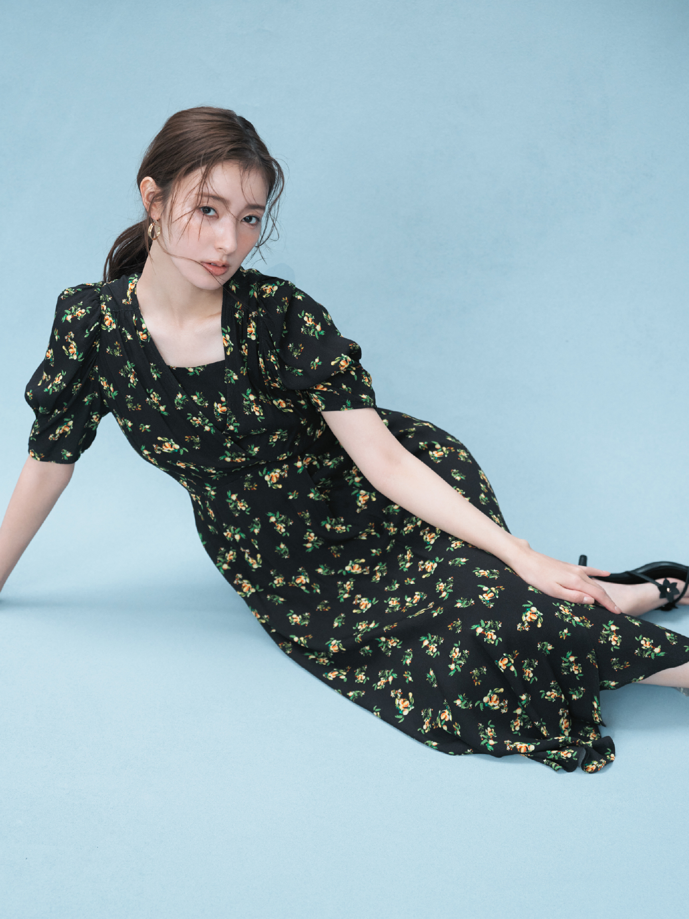 フルーツプリントレーヨンワンピース・クロスラインフープピアス・フラワーモチーフストラップサンダルを着用した女性