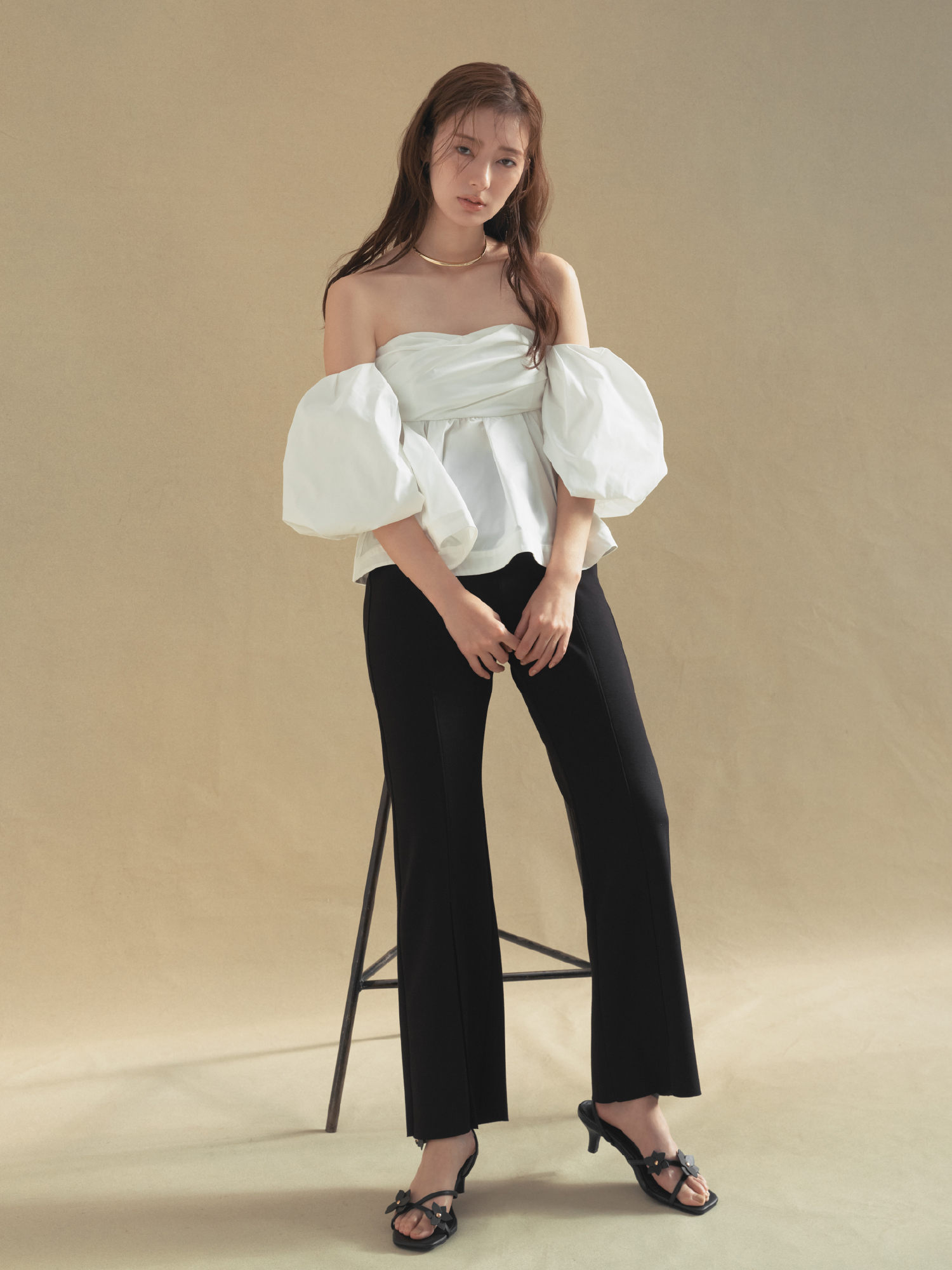 2wayボリュームスリーブベアブラウス・コンフォートメルティースリットパンツ・メタルチョーカーネックレス・フラワーモチーフストラップサンダルを着用した女性