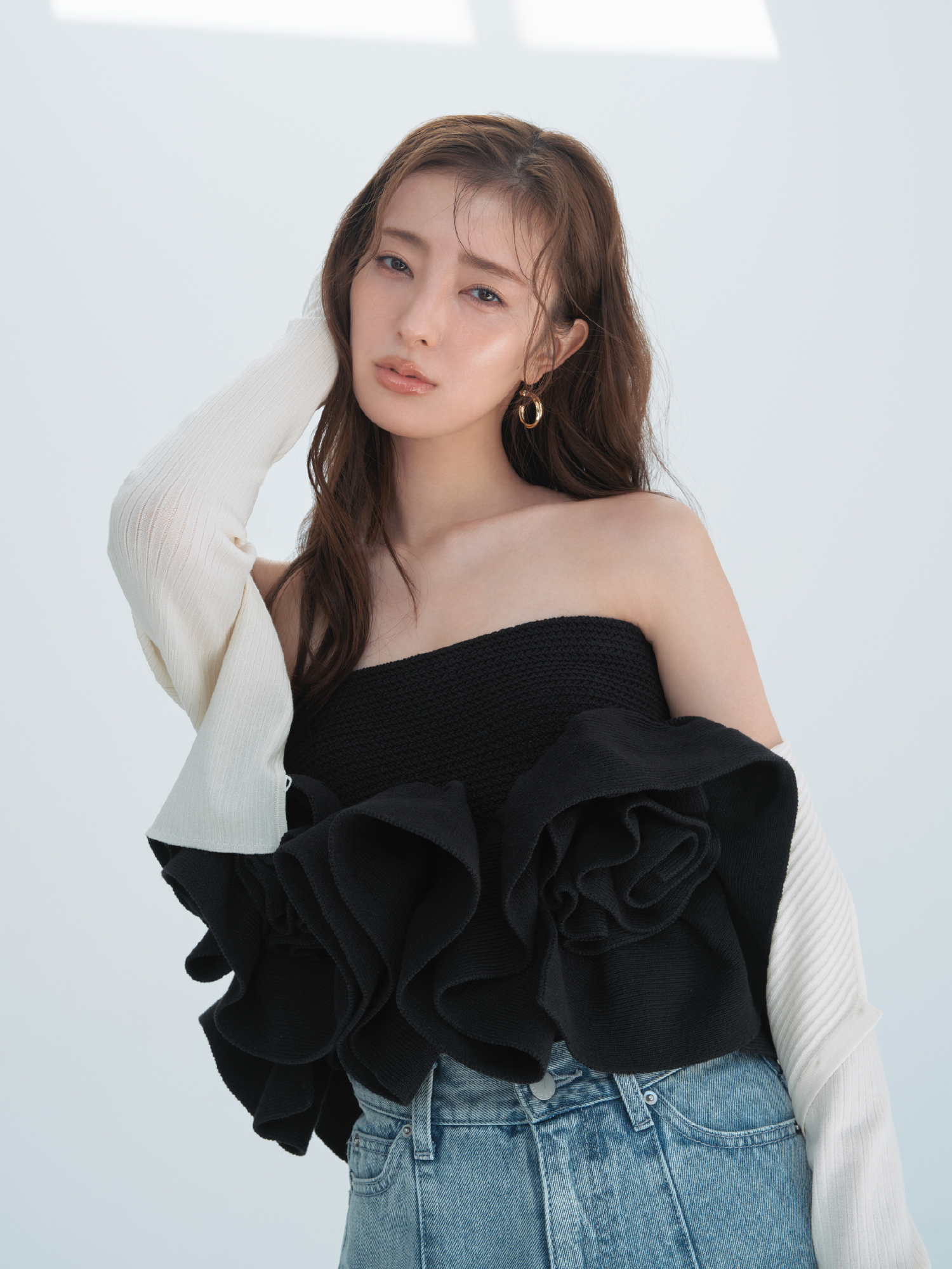 クロップドリブカーディガン・【00サイズあり】カットアウトバレルデニムパンツ・フラワーペプラムニットベアトップス・クロスラインフープピアスを着用した女性