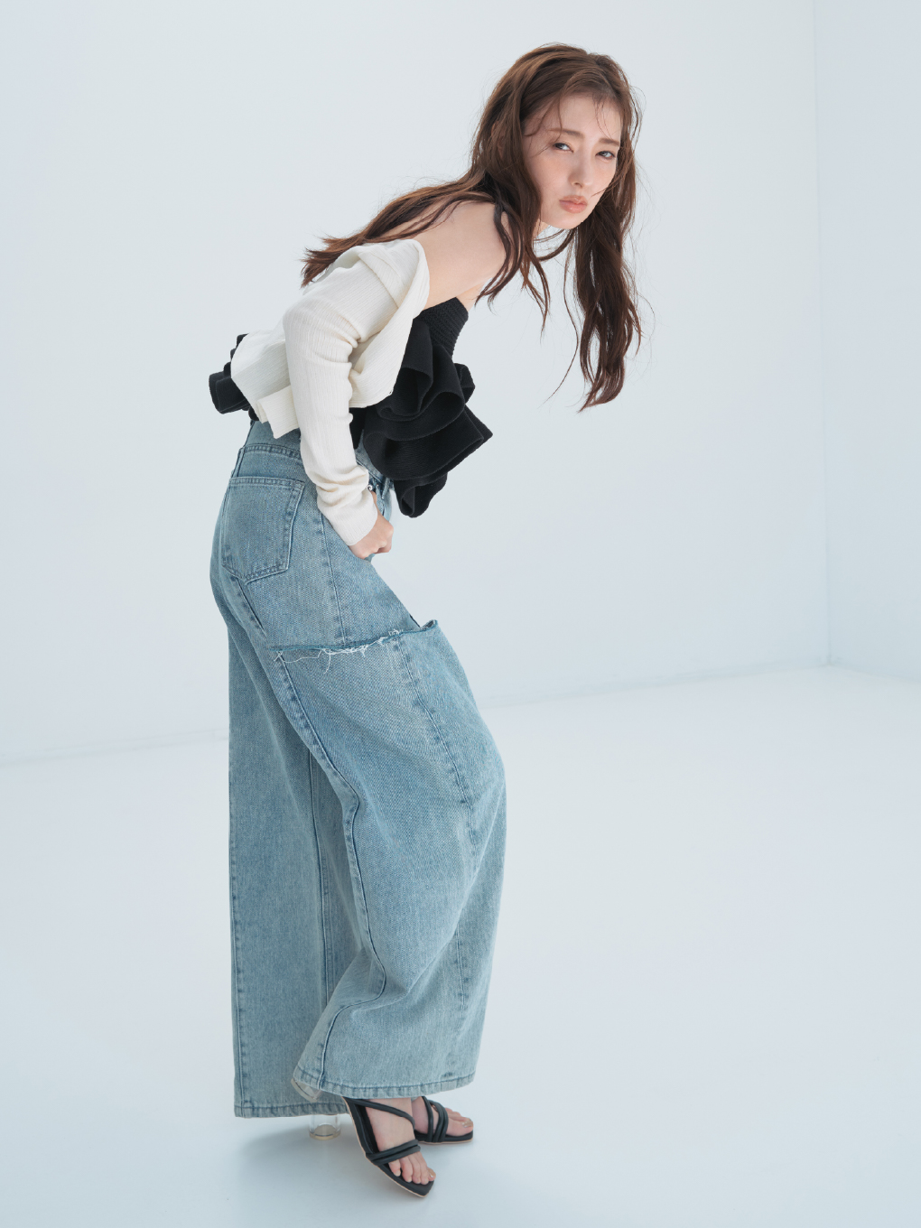 セミシアークロップドリブカーディガン・【00サイズあり】カットアウトバレルデニムパンツ・フラワーペプラムニットベアトップス・クロスラインフープピアス・クリアヒールサンダルを着用した女性