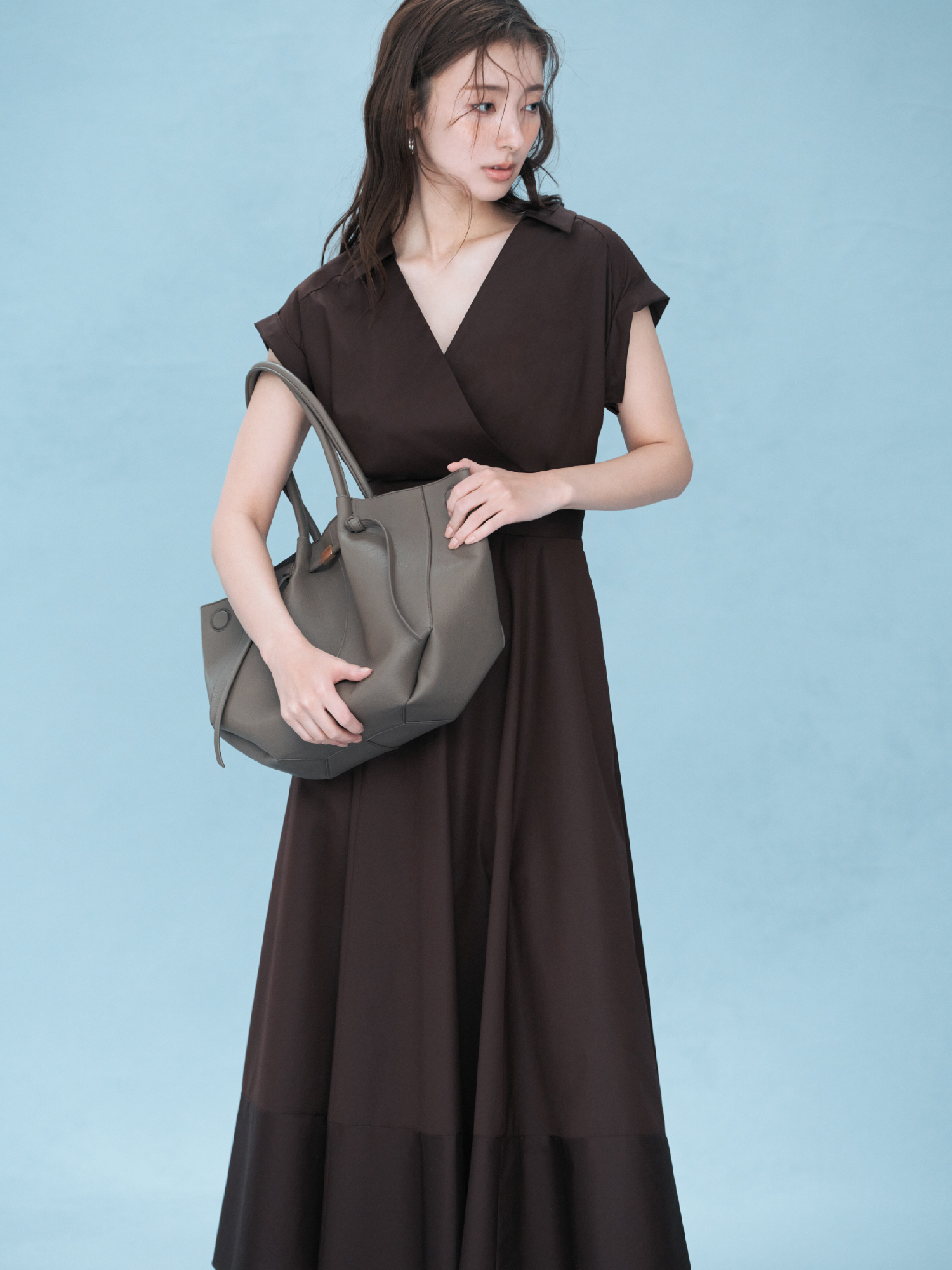 レースアップバックストライプシャツワンピース・クロスラインフープピアス・ベルトデザイントートバッグ・フラワーモチーフストラップサンダルを着用した女性