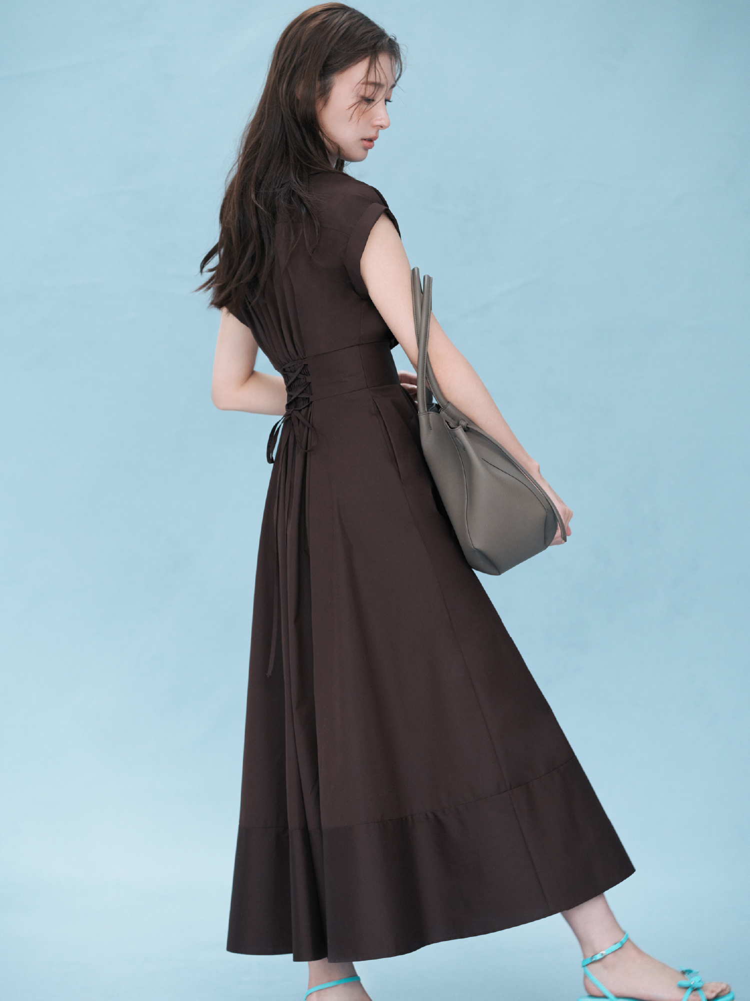 レースアップバックストライプシャツワンピース・クロスラインフープピアス・ベルトデザイントートバッグ・フラワーモチーフストラップサンダルを着用した女性