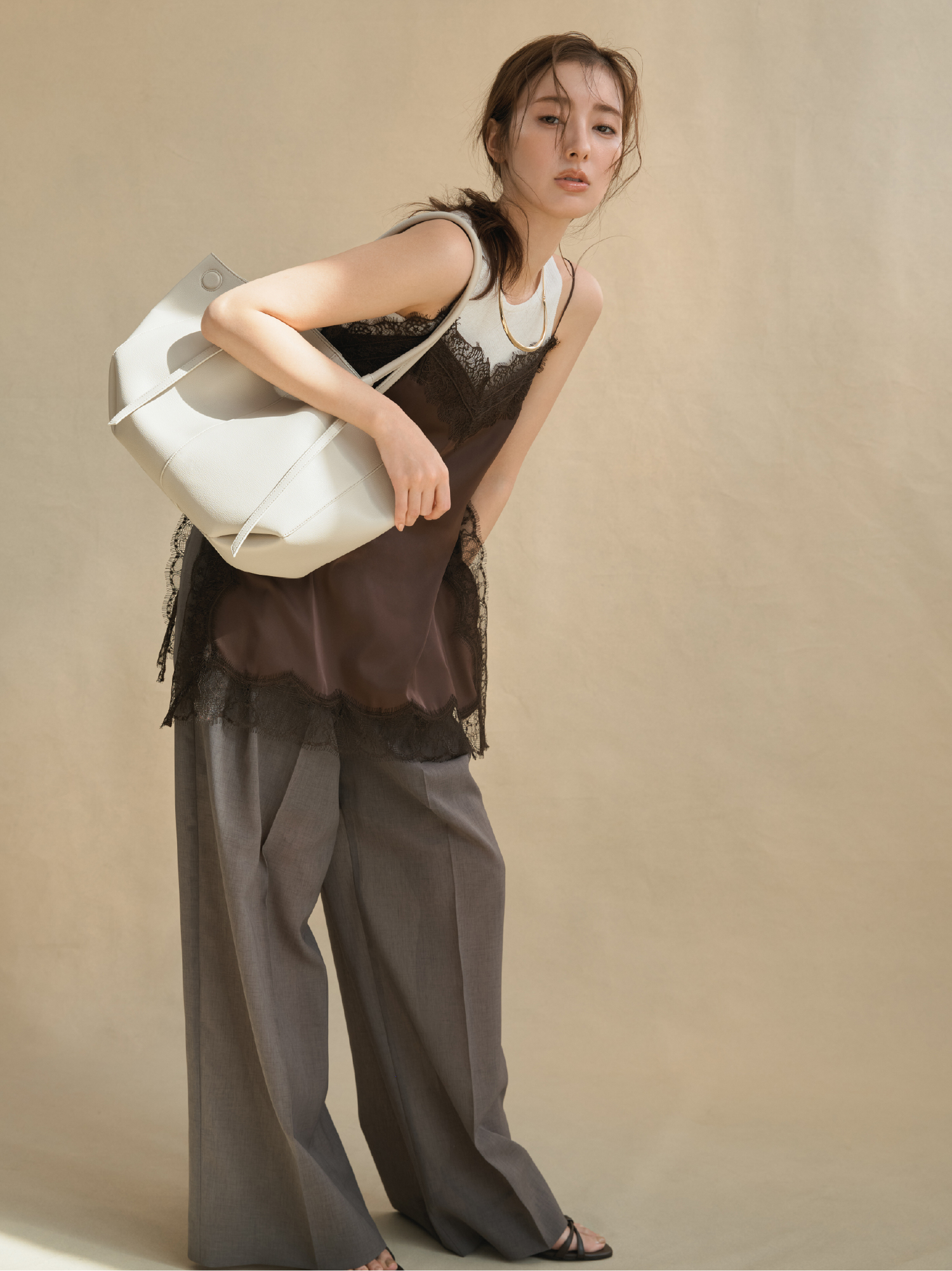 シアーリブニットレイヤードトップス・サイドスリットレーストリムキャミソール・セミシアーハイウエストパンツ・メタルチョーカーネックレス・ベルトデザイントートバッグ・ストラップウィーブサンダルを着用した女性