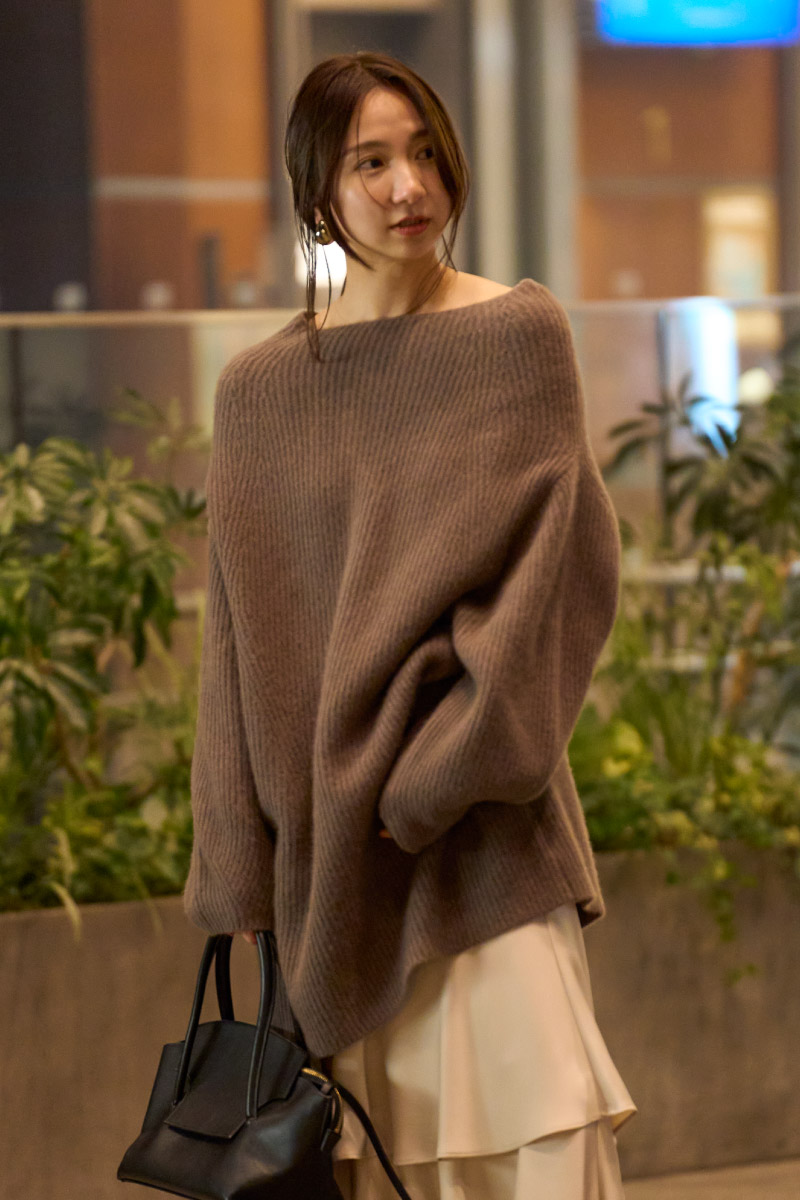 ブラウンのトップス・アイボリー色のスカートを履いた女性
