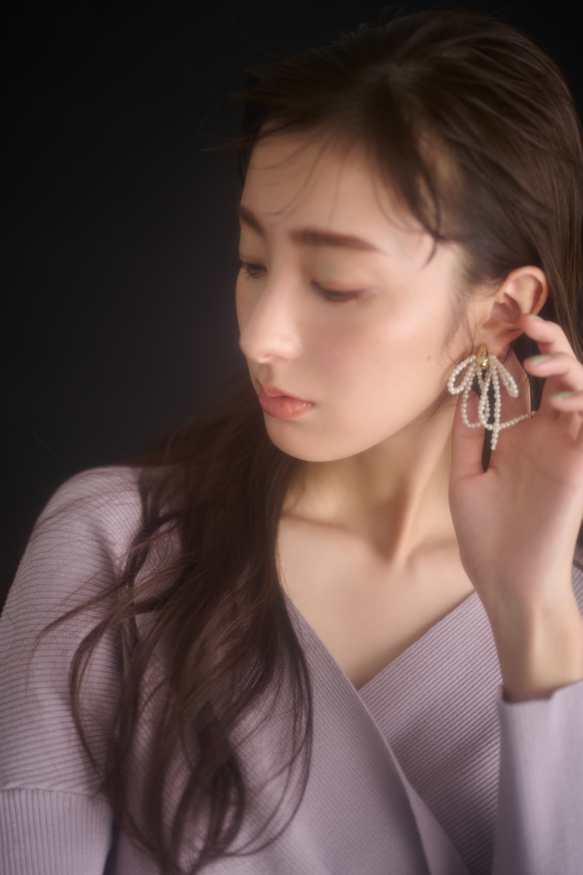 オフショルニットコンビワンピース・リボンドロップイヤリング・ナローストラップパンプスを着用した女性