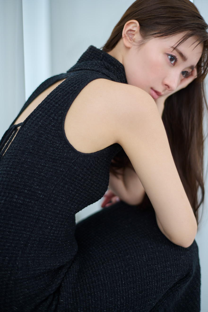 ホルターネックラメニットワンピース・チャンキートングサンダルを着用した女性