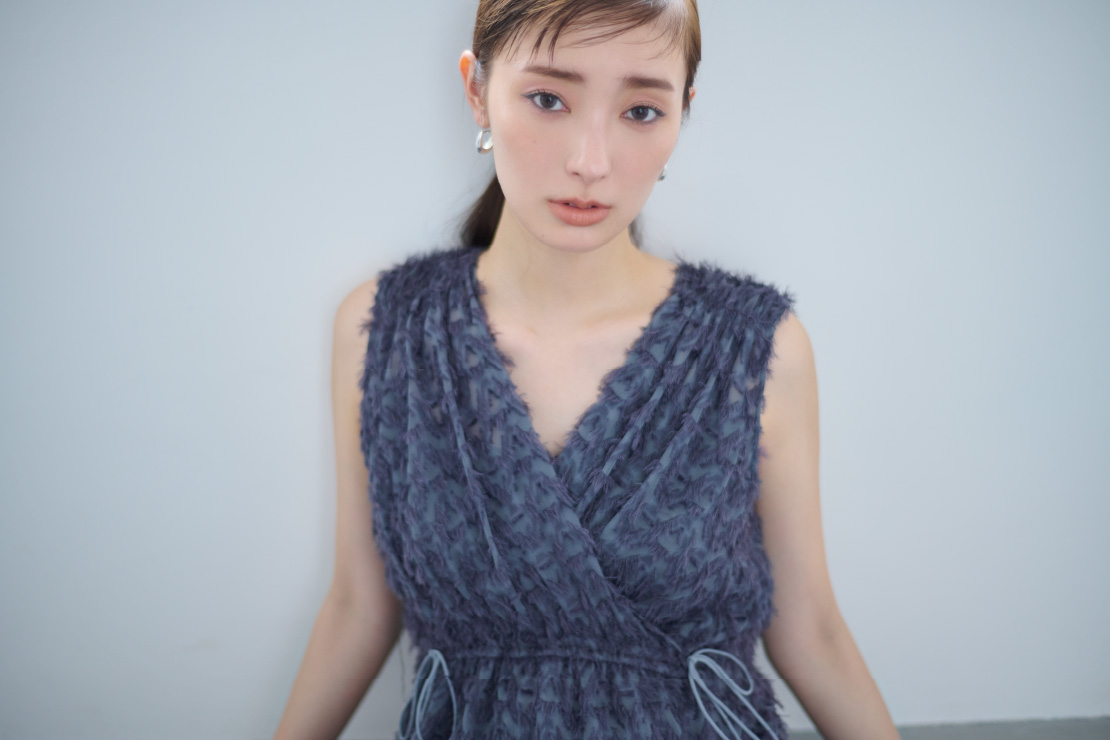 フリンジジャガードカシュクールワンピース・アソートフープピアス・シリンダーヒールサンダルを着用した女性