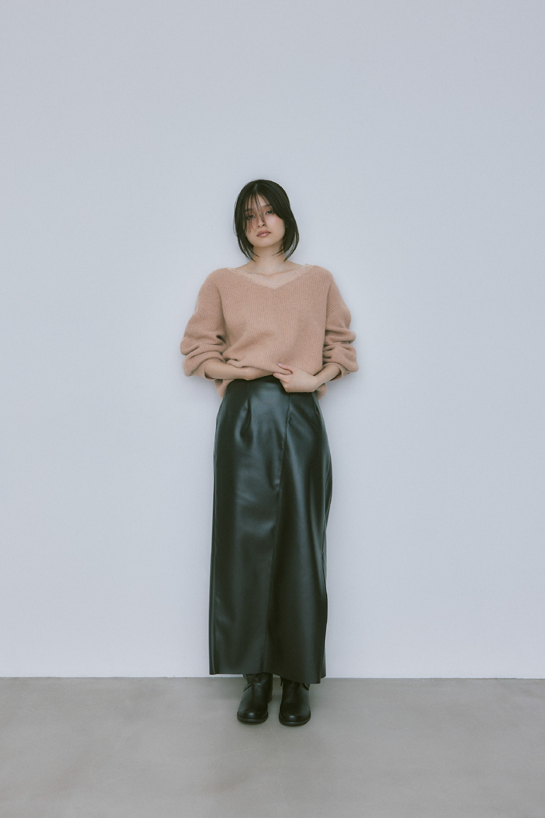黒のレザータイトスリットスカートを着用した女性