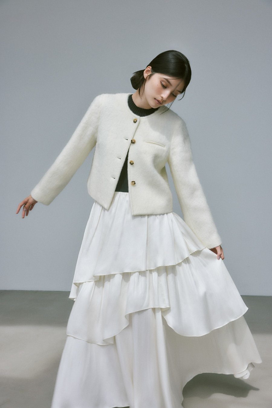 白いノーカラーシャギーショートジャケットを着用した女性