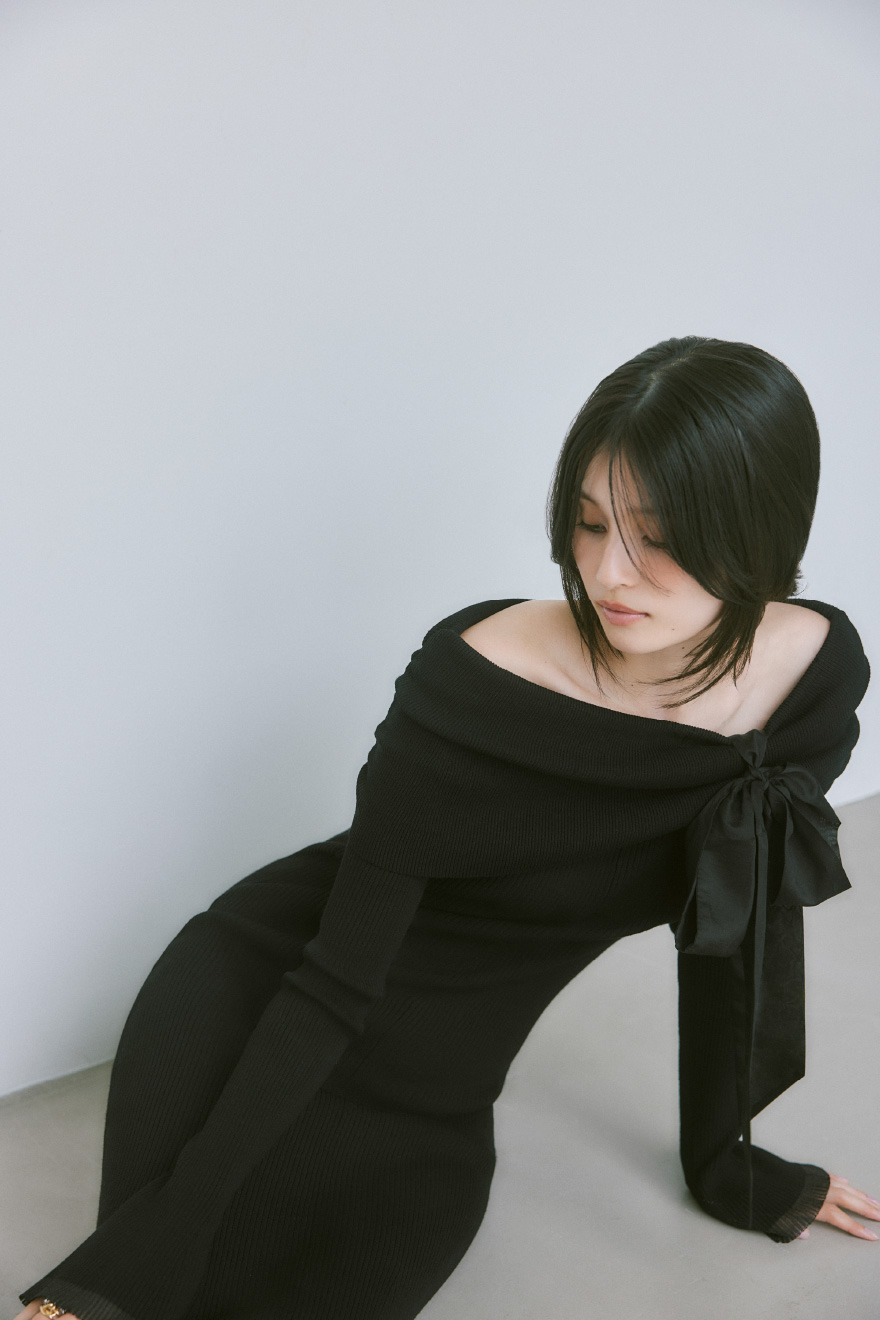 黒いオフショルリボンリブニットワンピースを着用したモデル