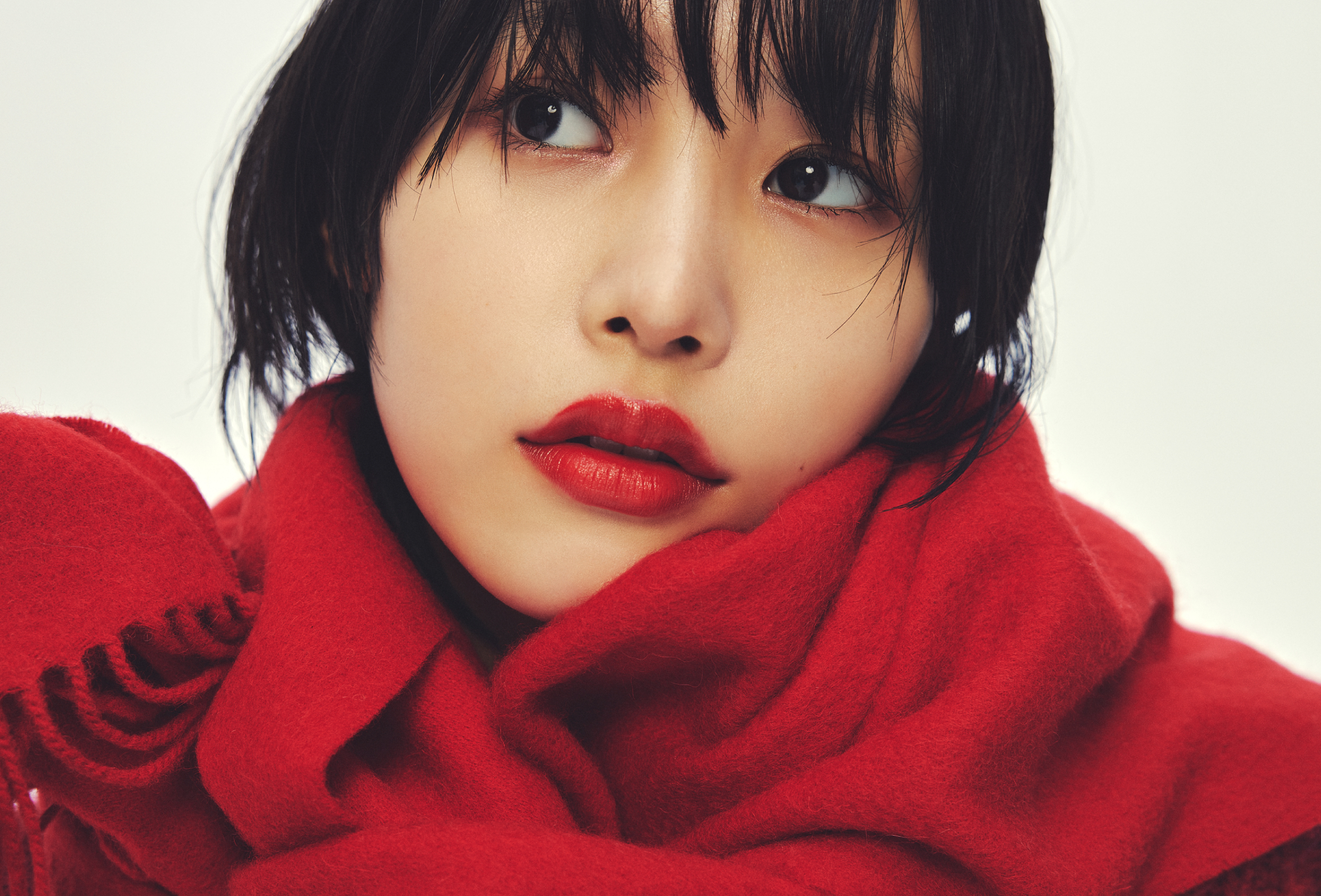 レッドのニットトップス・レッドのマフラーを着用した女性