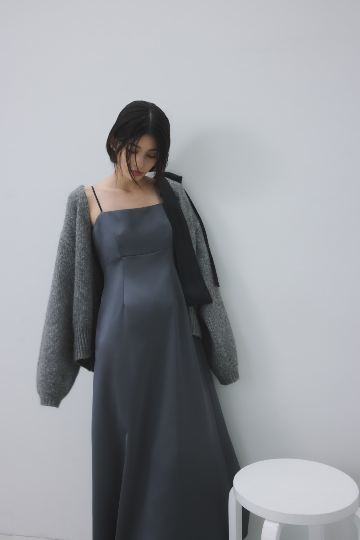 【NEW YEAR'S SPECIAL ITEM】カーデセットリボンショルダーワンピースを着用し白い椅子の横に立てているモデル画像