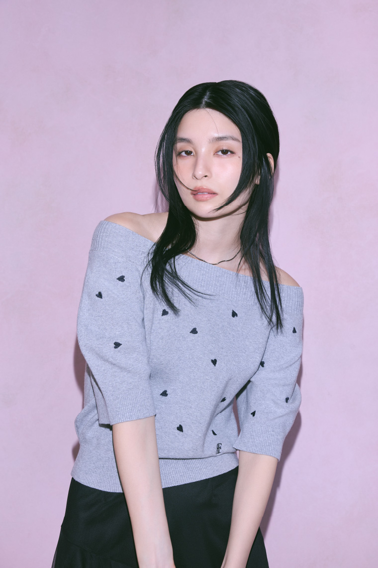 グレー色の２ｗａｙパフスリーブハートニットＰＯ、黒色のオープンカラーポロセットワンピースを着用してる女性のイメージ