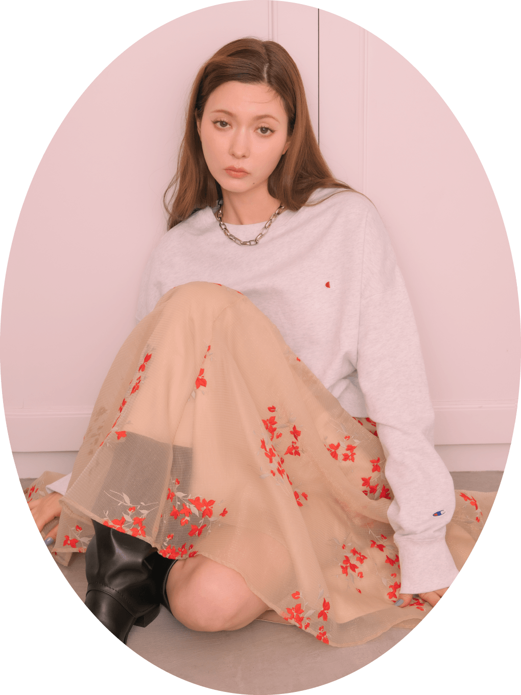 【Champion】クルーネックスウェット、シアーマグノリアスカート、ボリュームチェーンネックレス、ゲートルロングブーツを着用し床に座ってる女性のイメージ