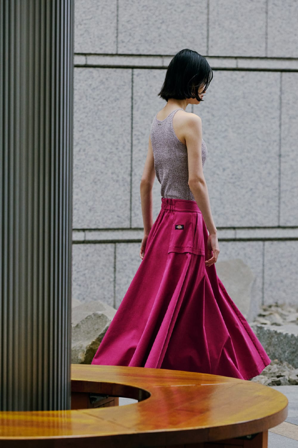 ピンク色のスカートを身につけた女性モデルの後ろ姿の画像