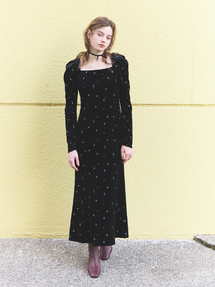 黒のベロアに小さなリボンの柄が入ったワンピースを着た女性