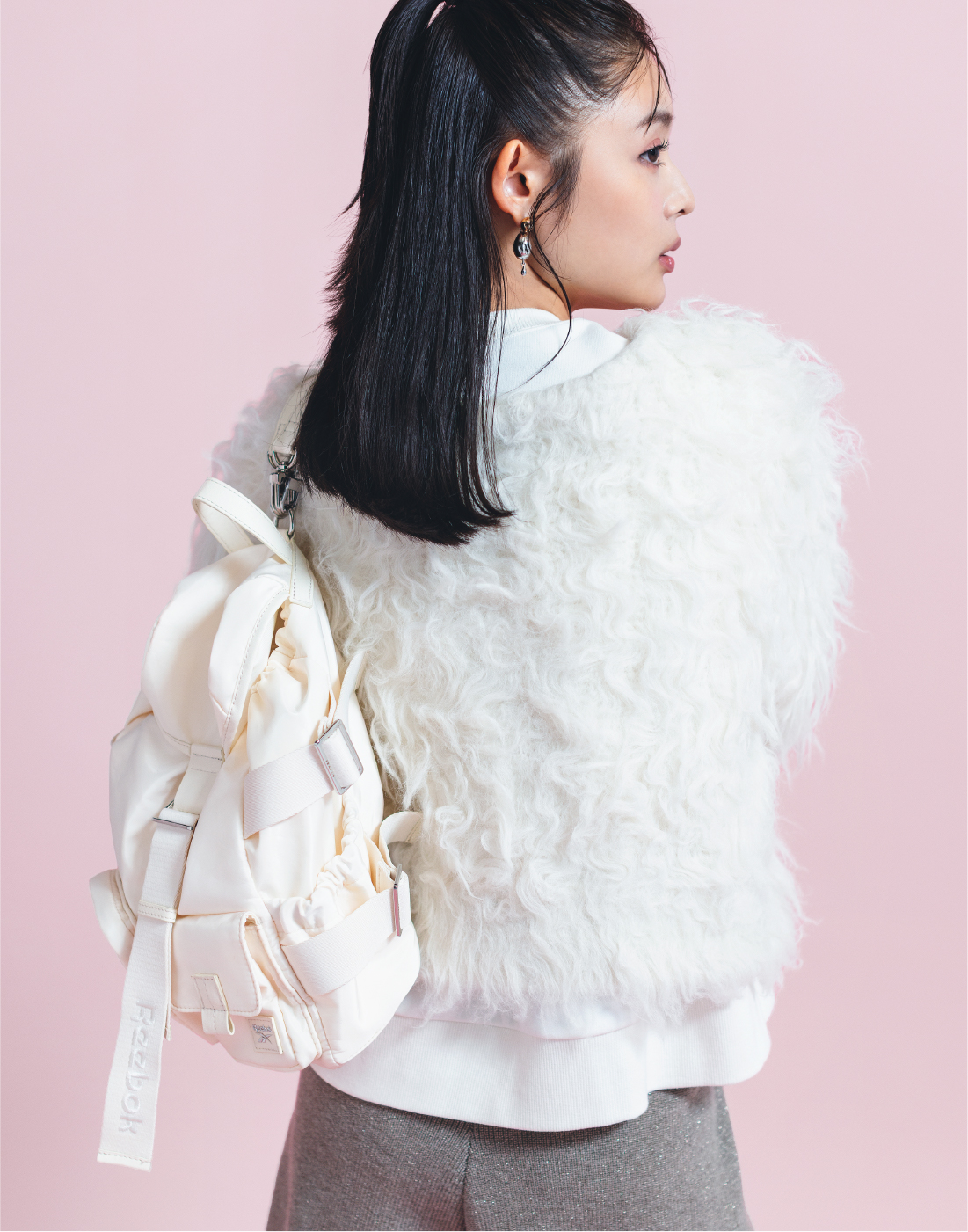 【Reebok】ナイロンリュックを着用した女性の後ろ姿