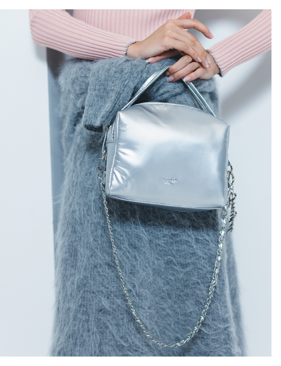 【Reebok】ナイロンハンドルバッグを持った女性の手元