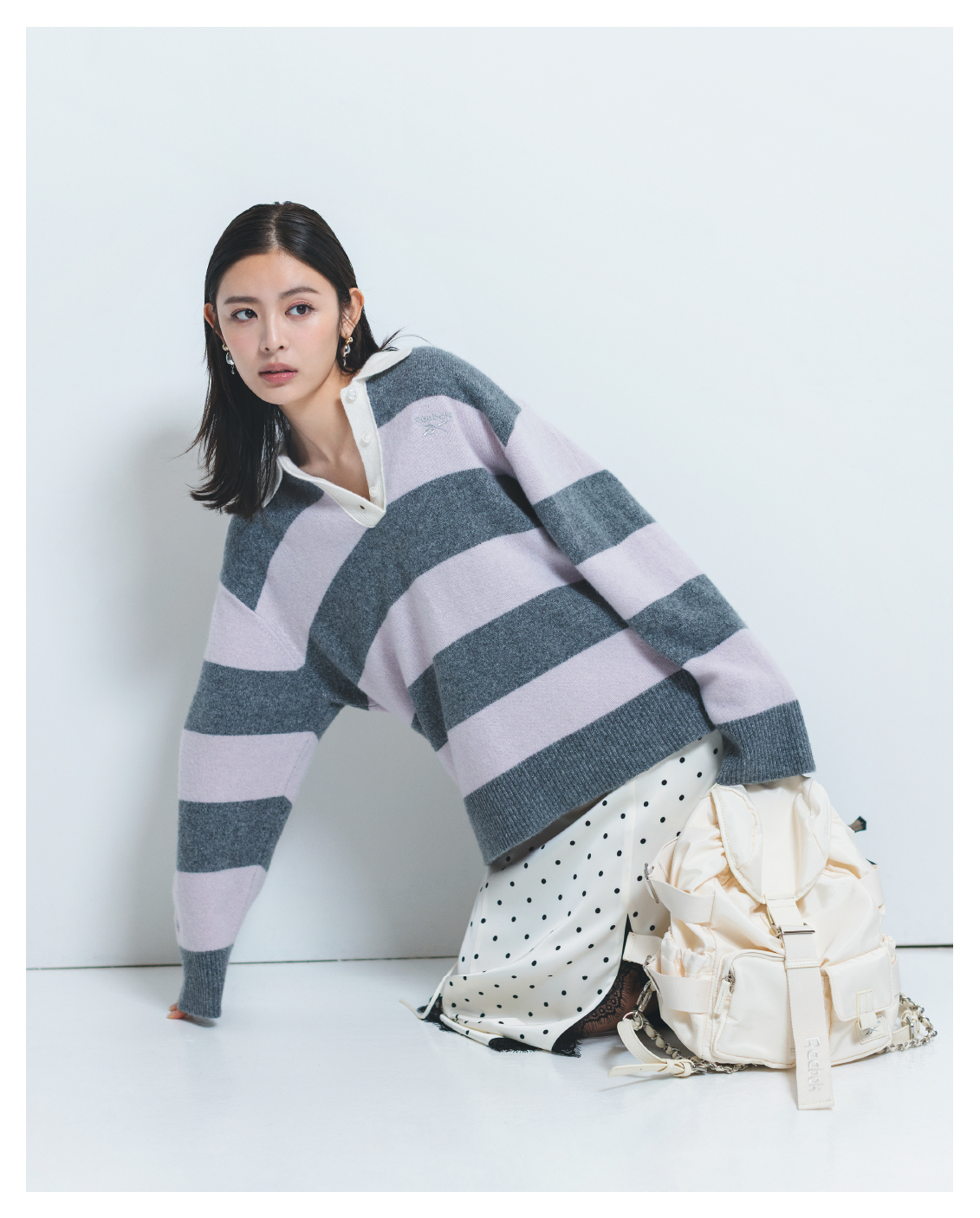 【Reebok】ラガーカラーポロニットプルオーバー・レーストリムキャミOP・【Reebok】ナイロンリュック・2WAYトリニティドロップピアスを着用した女性