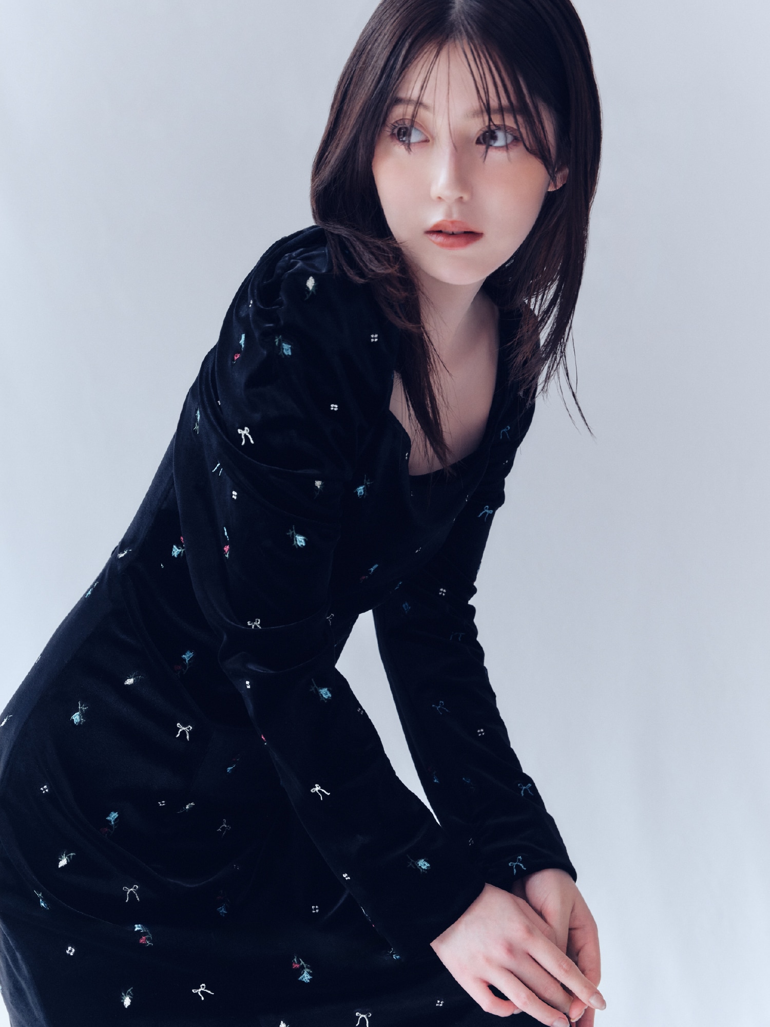 黒地にリボンモチーフを散らしたベロアナローワンピースの着用例