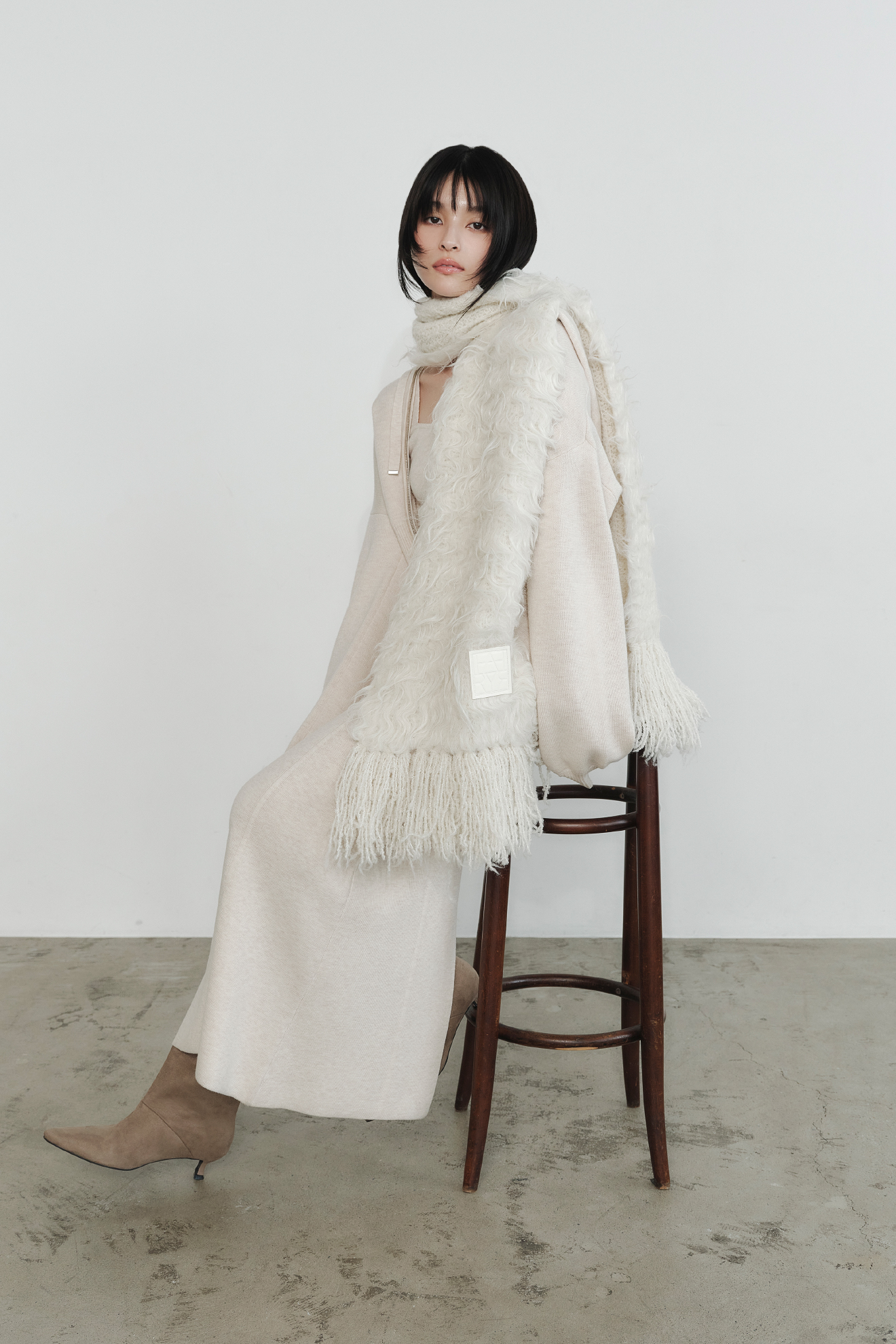 ジップパーカ&キャミワンピースセット・ブラッシュシャギーニットマフラー・キトゥンヒールロングブーツを着用した女性の画像