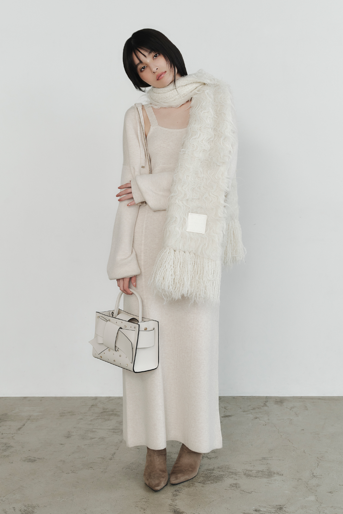 ジップパーカ&キャミワンピースセット・ブラッシュシャギーニットマフラー・【ルエル】ビジューパールリボンミドルバッグ・キトゥンヒールロングブーツを着用した女性の画像