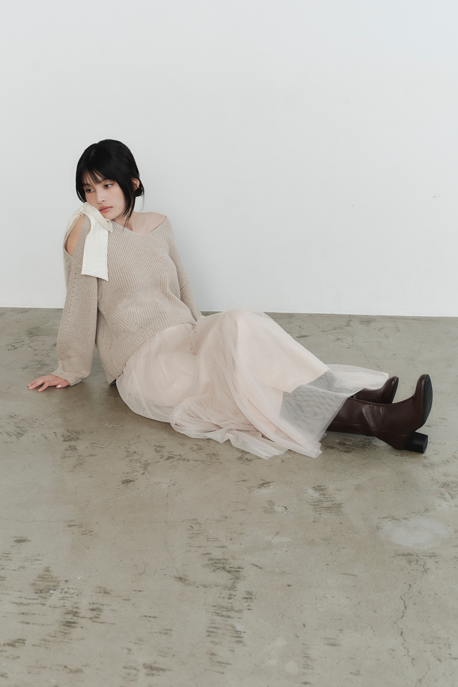 リボンニットプル＆チュールスカートセット・ラウンドトゥロングブーツを着用した女性の画像