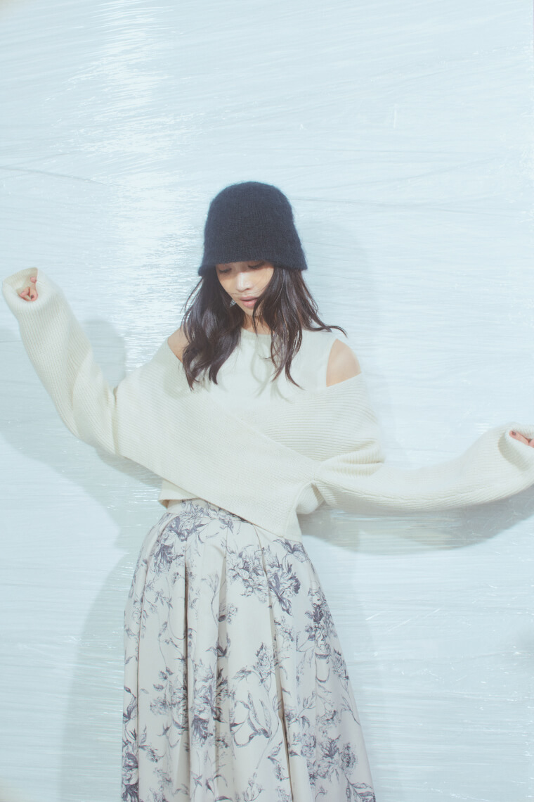 白ニット・花柄ドレスを着た女性