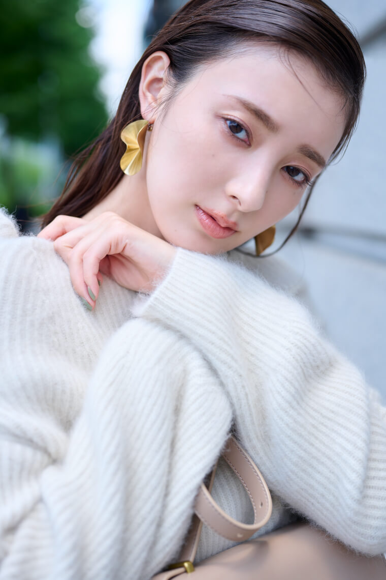 アイボリーのニットとスカートを履いた女性