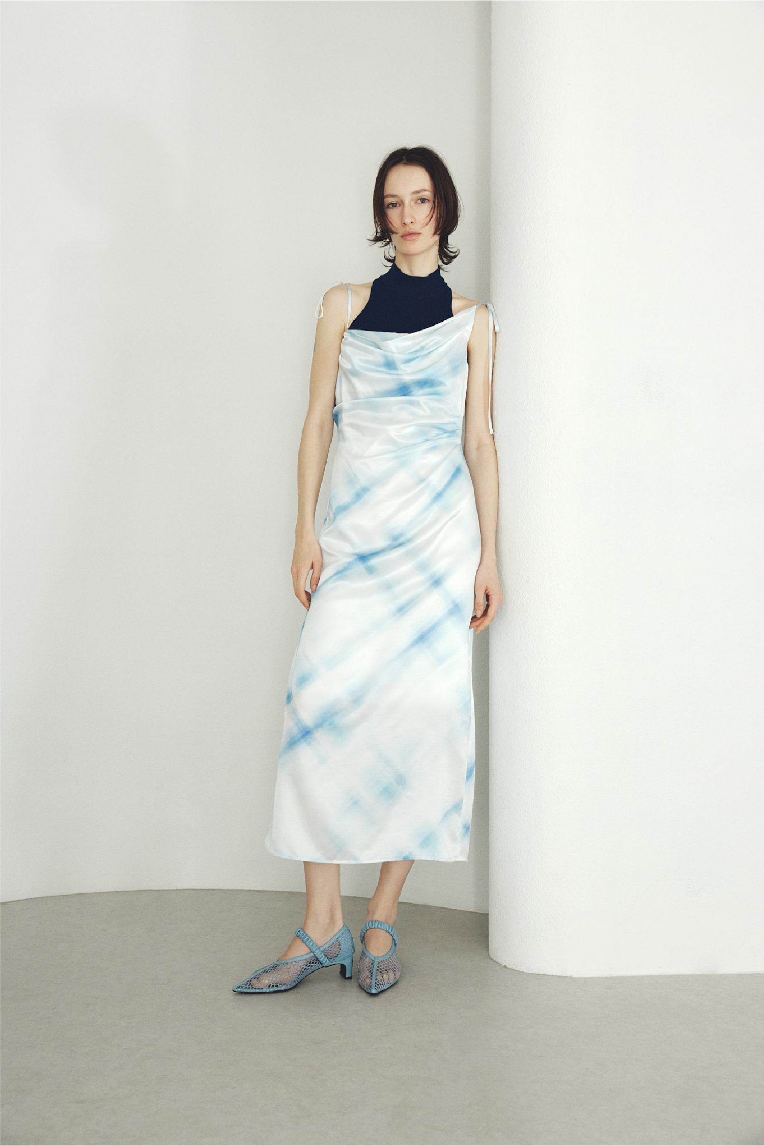 タックドレープキャミワンピース・シルクブレンドカップインホルターニット・ポインテッドトゥメッシュサンダル・フープパールピアスを着用した女性の画像