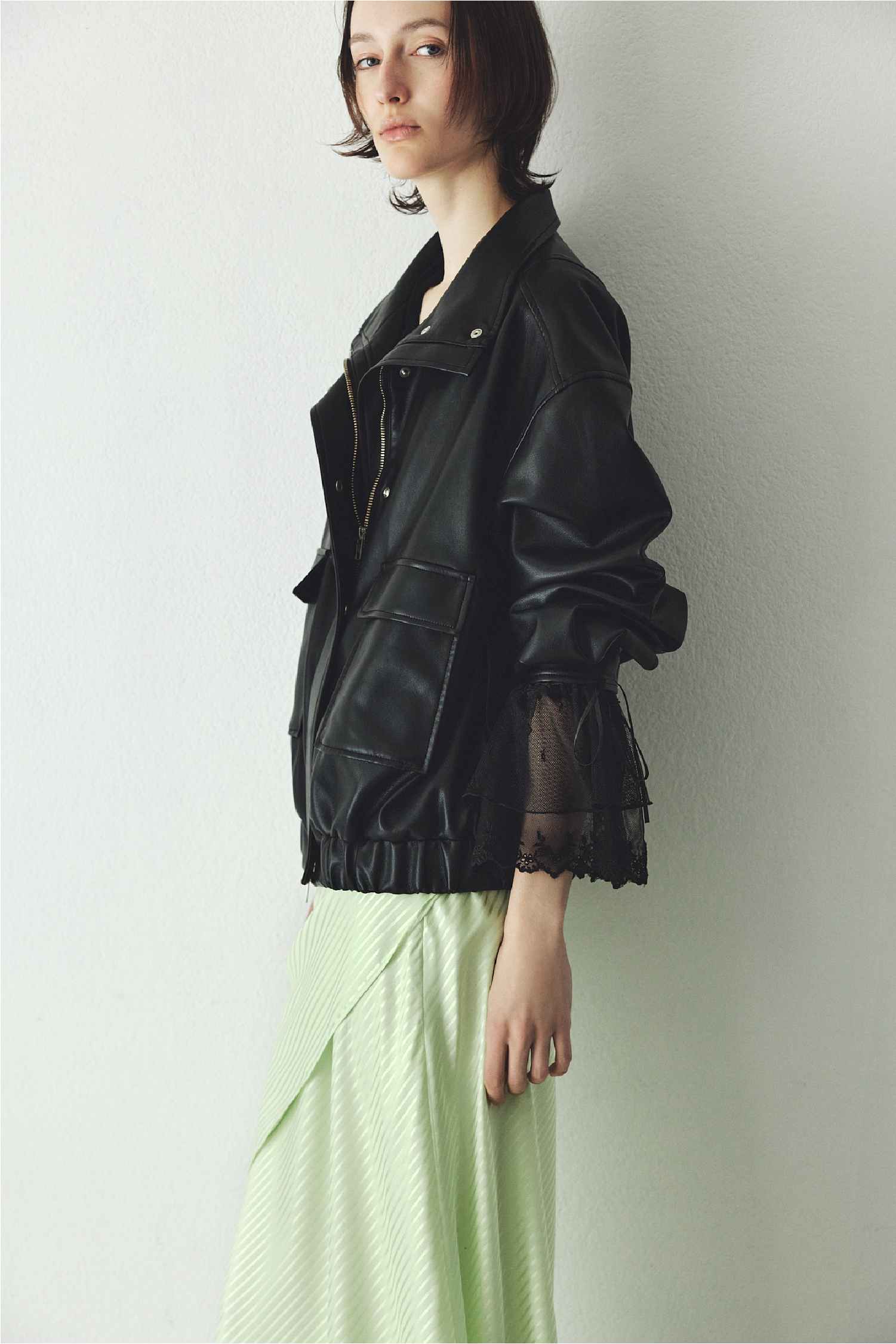 スタンドカラーオーバーサイズブルゾン・スカーフセットサテンナロースカート・ラッフルデザインチュールエンブロイダリーブラウスを着用した女性の画像