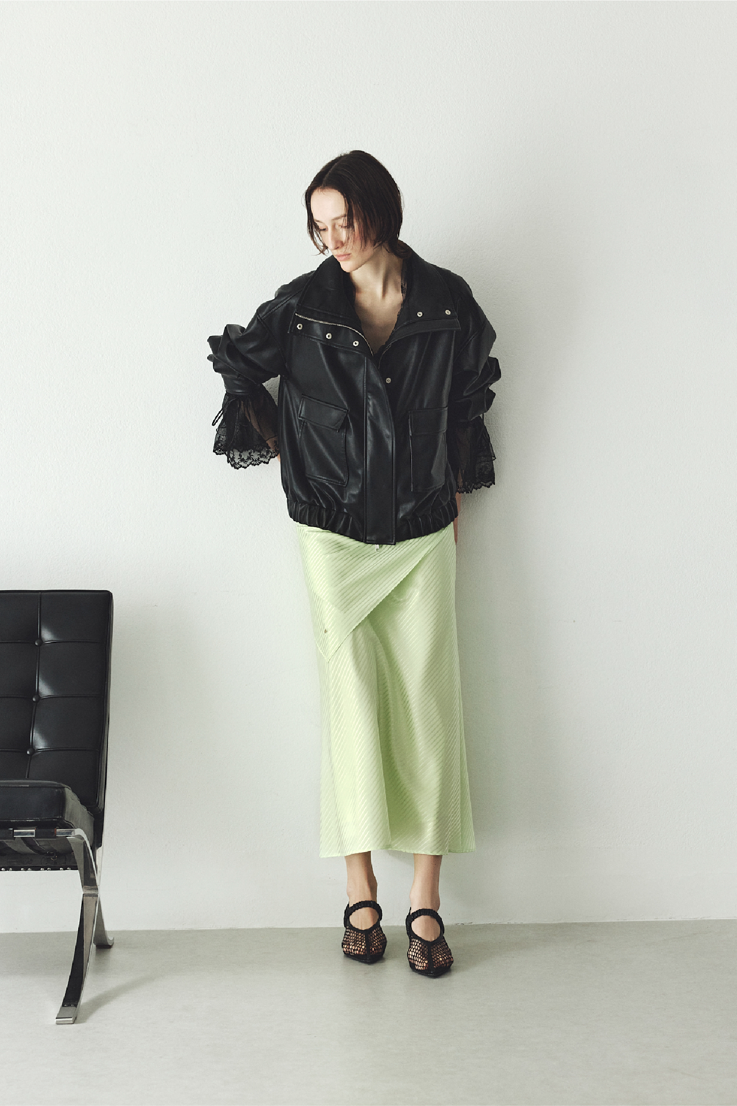 スタンドカラーオーバーサイズブルゾン・スカーフセットサテンナロースカート・ポインテッドトゥメッシュサンダル・ラッフルデザインチュールエンブロイダリーブラウスを着用した女性の画像