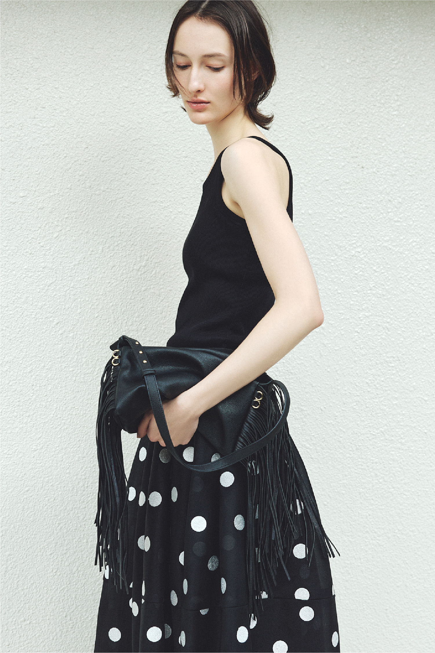 カップインリブタンクトップ・ボンディングチュール構築スカート・フリンジスラウチバッグを着用した女性の画像