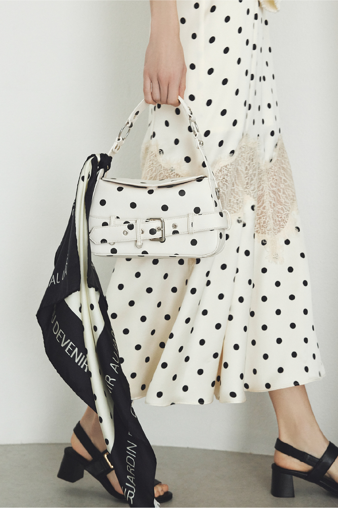 レーストリムマーメイドワンピース・バックルベルトサンダルを着用した女性の足元の画像